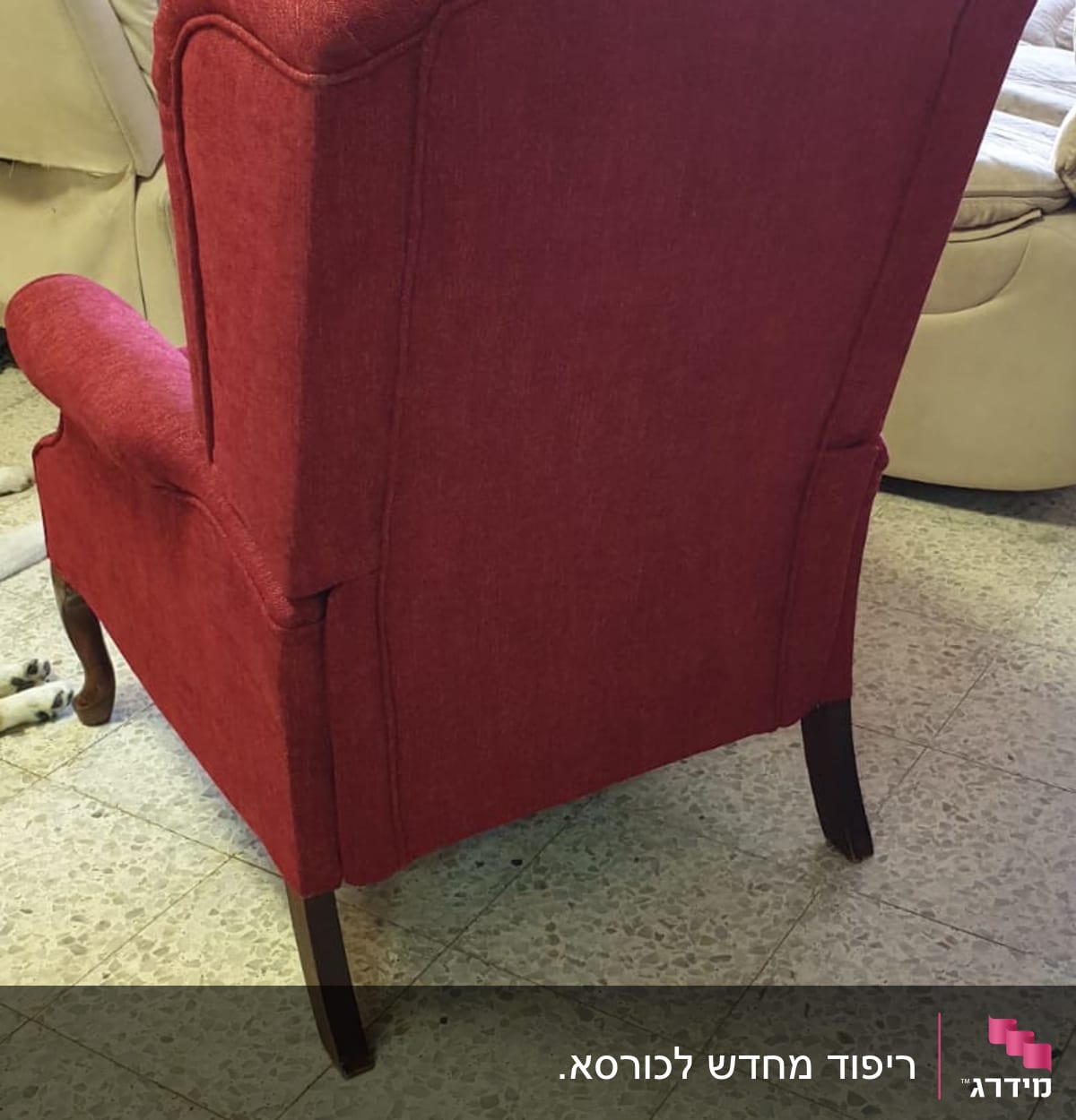 כורסה מרופדת באדום עם רגלי עץ כהות